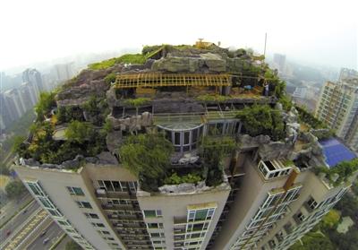 　　昨日，身穿橘黃色馬甲的工作人員在人濟山莊樓頂拆除違章建筑。新京報記者 吳江 攝