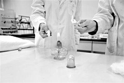 實驗人員操作的燃燒檢測法中，真蠶絲離開火焰就熄滅(左)。