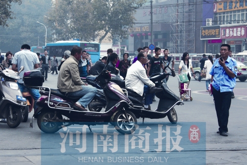 　火車站廣場北側(cè)，幾輛摩的正在等客