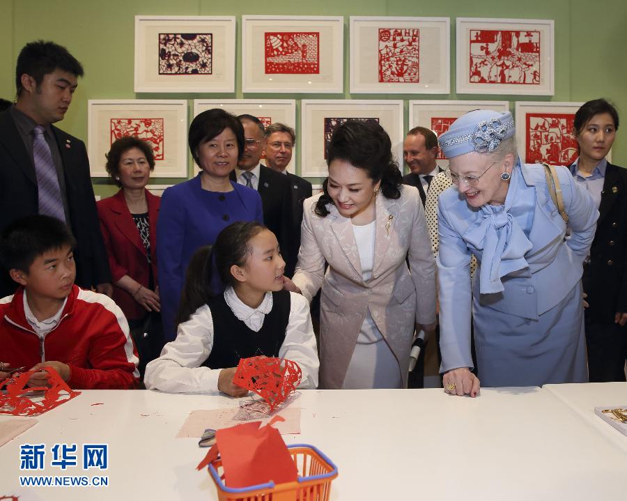 這是彭麗媛和瑪格麗特二世與根據(jù)安徒生童話中人物和情節(jié)制作剪紙的孩子交談。