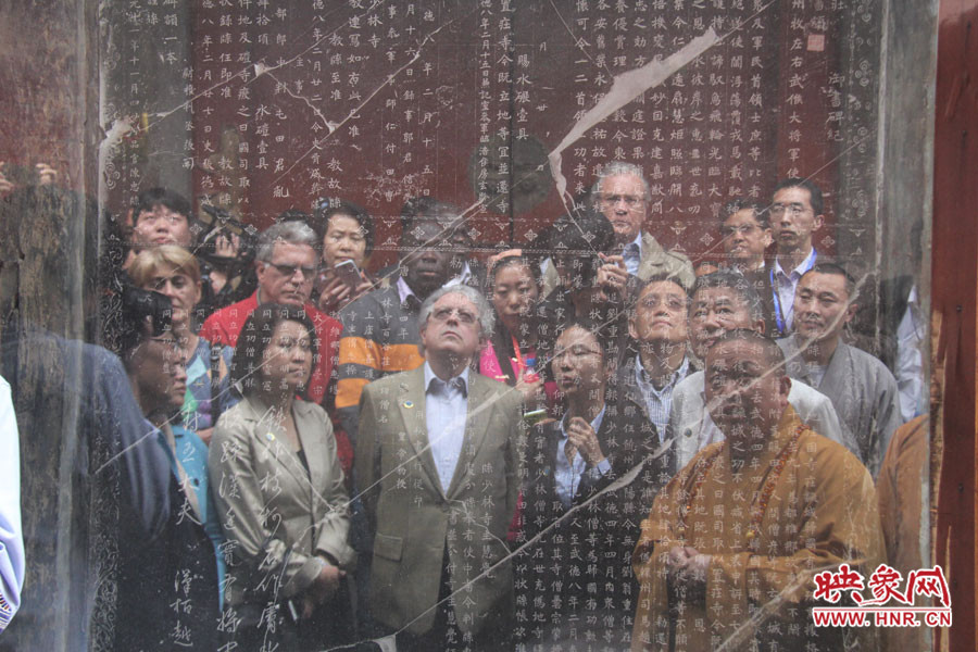 在一塊石碑前，少林寺方丈正在講解