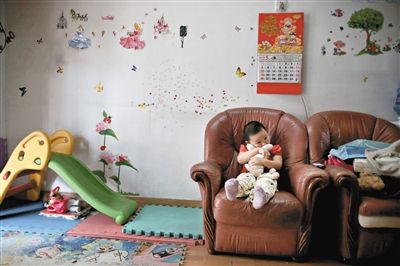 6月14日，未婚媽媽于軍的家里。女兒悅悅抱著兔子玩偶，在聽媽媽手機上的兒歌，這個4歲女孩喜歡兔子。