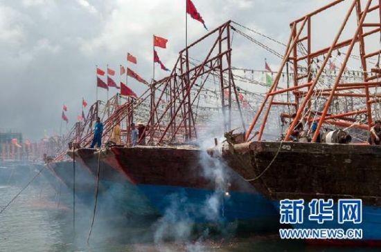 2013年8月1日 南海開漁日 臨高迎新港 8月1日，海南省臨高縣漁民在船上鳴放鞭炮慶祝武蓮港開港。