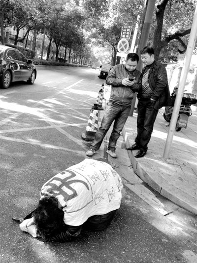 兩名接訪人員與患有癌癥的訪民段新德合影時(shí)，在拍照時(shí)查看手機(jī)。