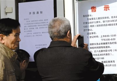 昨日，家長(zhǎng)在西安市楓韻幼兒園查看有關(guān)兒童體檢的告示。
