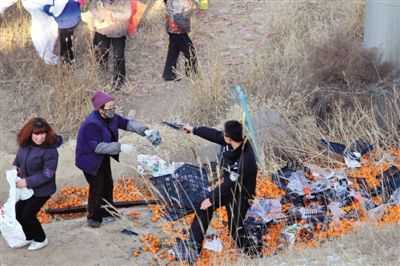 1月4日，連霍高速蘭州市榆中縣和平鎮(zhèn)段，一名警察舉著槍驅(qū)散哄搶橘子的村民。圖/CFP