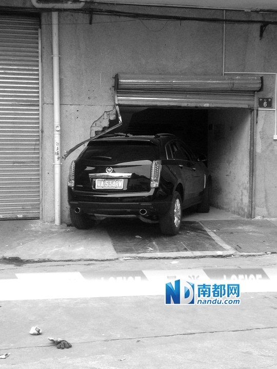 　昨日，凱迪拉克撞人后停在一倉(cāng)庫(kù)門(mén)口，車(chē)后有一攤血跡。 南都記者陳杰生攝