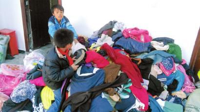 學(xué)生在幫忙整理收到的捐贈(zèng)衣服。得石中心校供圖