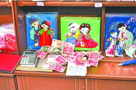　　2012年6月21日，在朝鮮羅先特別市的一家商店里，柜臺上散落著一些人民幣。在朝鮮，人民幣比本國