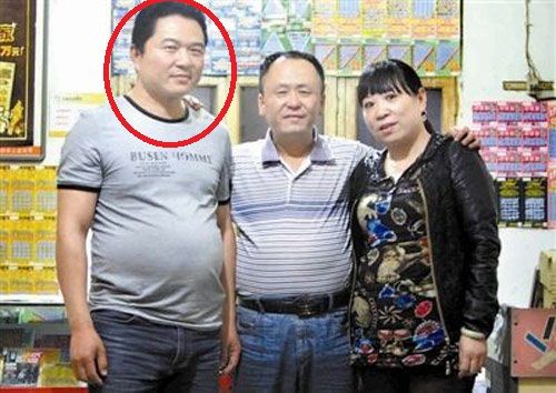 中獎(jiǎng)?wù)呲w應(yīng)光(左 腦袋畫(huà)了紅圈圈那位大哥)和彩票投注站老板張老二(中)及張老二的妻子合影