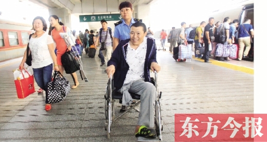李剛手術(shù)后歸來，在車站工作人員幫助下走出鄭州火車站站臺  東方今報首席記者 張曉冬 攝