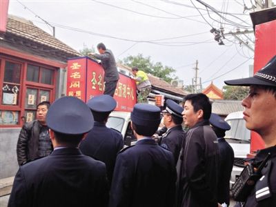 昨日下午,東城區(qū)工商、城管、公安等部門(mén),對(duì)雍和宮附近的預(yù)測(cè)中心進(jìn)行清理整頓,站在車(chē)頂?shù)膬擅と苏鸪患摇邦A(yù)測(cè)中心”的招牌。因雍和宮、白云觀等文化景點(diǎn)外聚集大量算命先生,被媒體稱(chēng)為“算命一條街”。本版攝影/新京報(bào)記者 李寧 攝