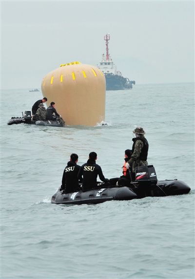18日，搜救人員準備將氣囊捆綁到沉沒客輪上。