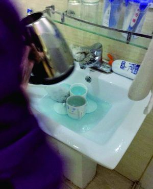 酒店服務(wù)員用潔廁液刷燒水壺和茶杯。