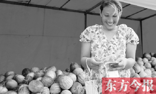 昨日，開封瓜農(nóng)史瑩瑩幸福地數(shù)著賣瓜錢 東方今報記者 沈翔 攝