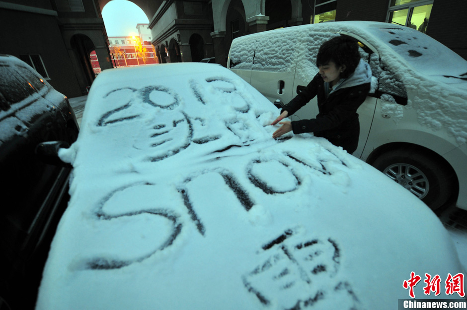 11月18日，行人在車輛的積雪上涂鴉。