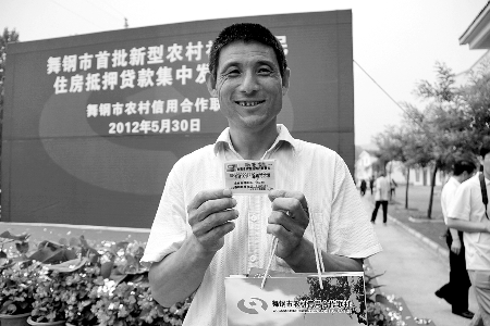 領(lǐng)到貸款，農(nóng)民開心地笑了。