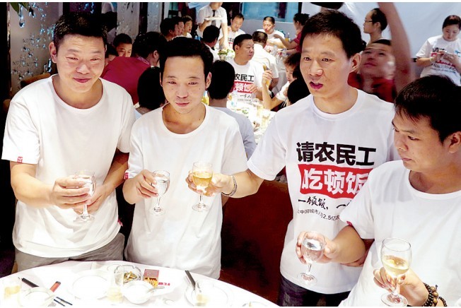 活動(dòng)發(fā)起人張楠（右二）給農(nóng)民工敬酒。