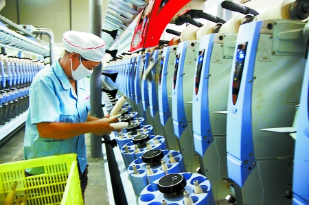 7月3日，在鄧州市永泰棉紡有限公司電腦控制全自動紡紗車間，紡織工人正在生產(chǎn)棉紗。