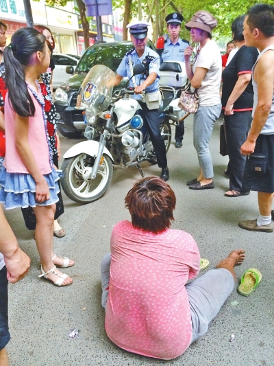在鄭州優(yōu)勝南路東三街交叉口向東100米處，一名短發(fā)中年女子平躺在路南快車道上，身旁還有一只掉落的拖鞋