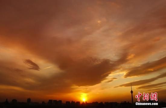 12月8日下午，強(qiáng)烈的西北風(fēng)光臨北京，吹散了籠罩全城上空的霧霾，冬日罕見的艷麗晚霞映紅了半邊天。