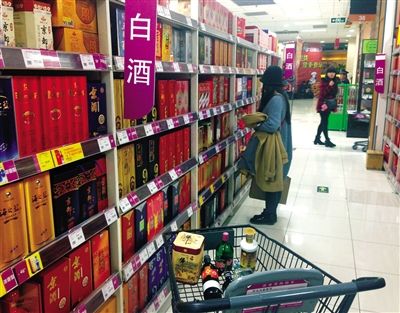 顧客在商場(chǎng)的高檔白酒貨架前駐足挑選。春節(jié)臨近，受“禁令”影響，以高檔白酒為代表的節(jié)日禮品市場(chǎng)面臨考驗(yàn)。記者 王遠(yuǎn)征 攝