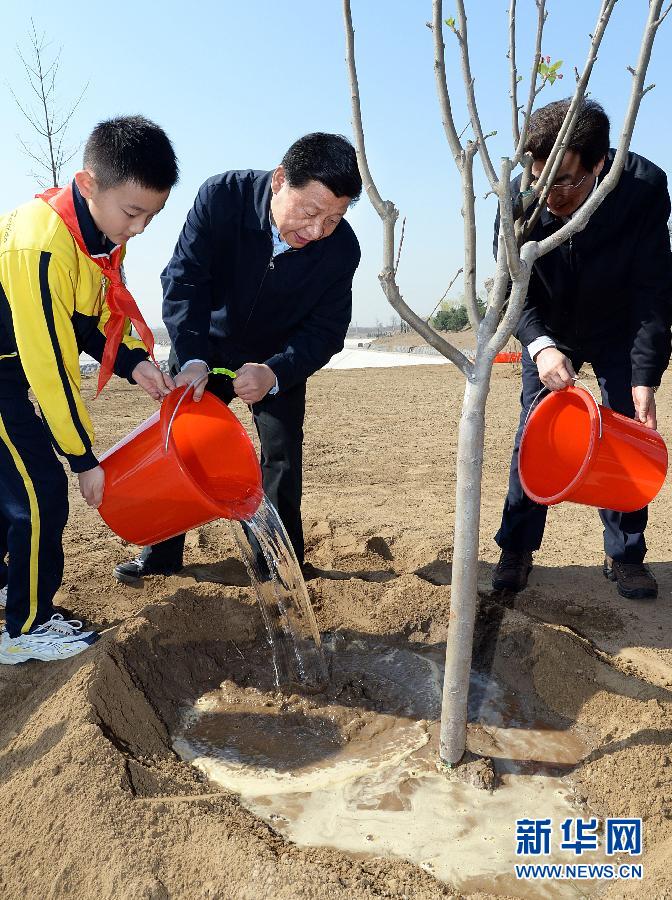 這是習(xí)近平同大家一起給剛栽下的樹(shù)苗澆水。