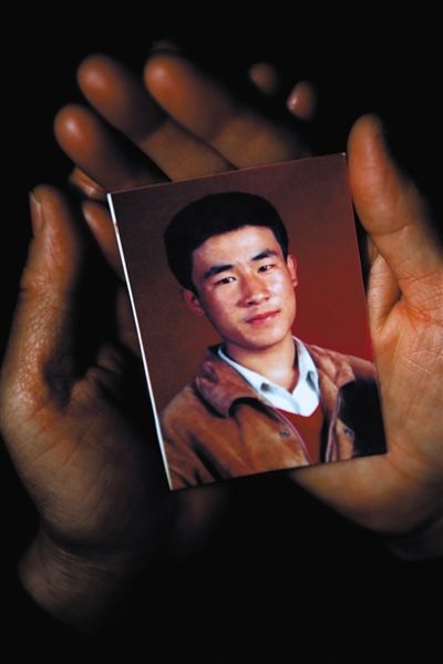 尚愛(ài)云捧著兒子的照片。