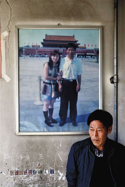 11月14日，承德市平泉縣，潘小梅父母的家，潘小梅父親靠在墻上，身后掛著數(shù)年前他和潘小梅在北京的合影照片。新京報記者