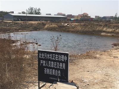 化肥廠滲坑的三分之一經(jīng)過(guò)治理，但水質(zhì)仍然呈黃褐色。
