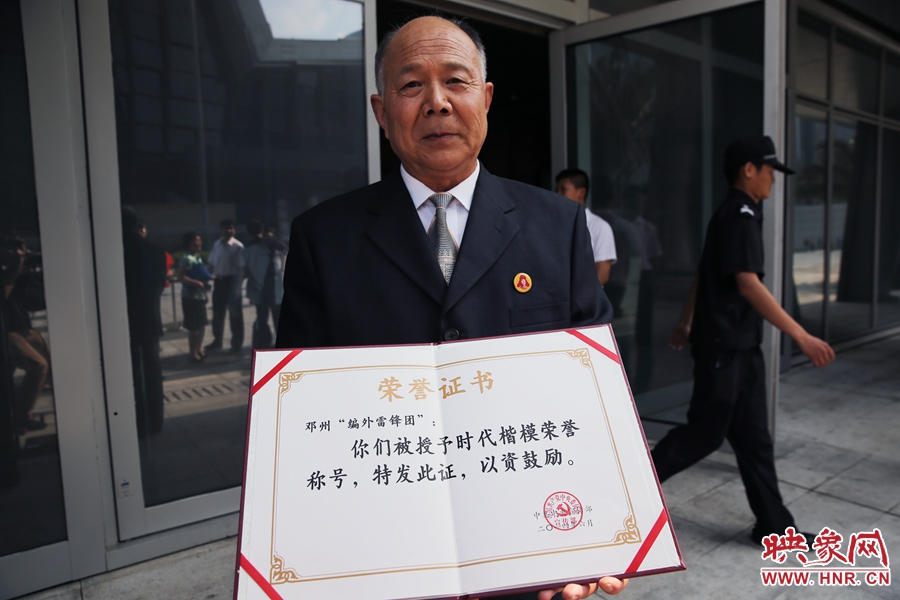 河南鄧州“編外雷鋒團(tuán)”團(tuán)長(zhǎng)宋清梅向眾多記者展示中宣部授予的“時(shí)代楷?！睒s譽(yù)證書。