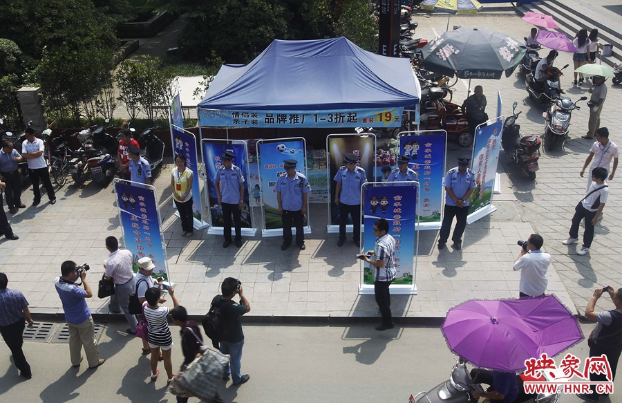 執(zhí)法人員用宣傳牌圍擋占道經營攤位。