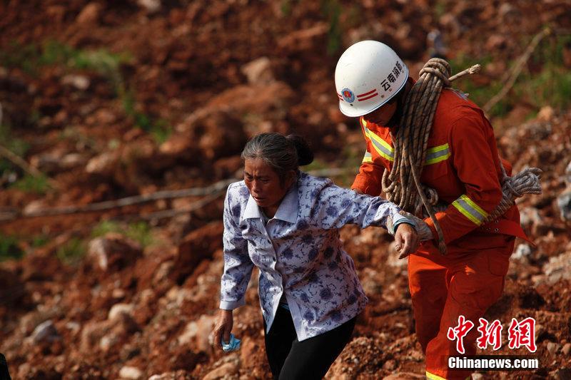 一位消防戰(zhàn)士將一位失去親人的老人扶離滑坡點(diǎn)。