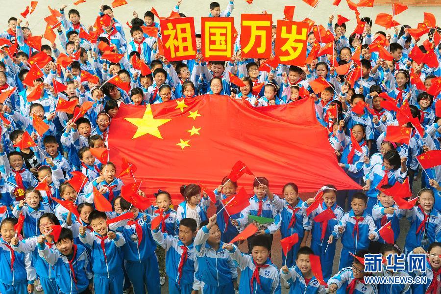 9月26日，安徽省阜陽市北城小學(xué)分校的學(xué)生與國旗合影。
