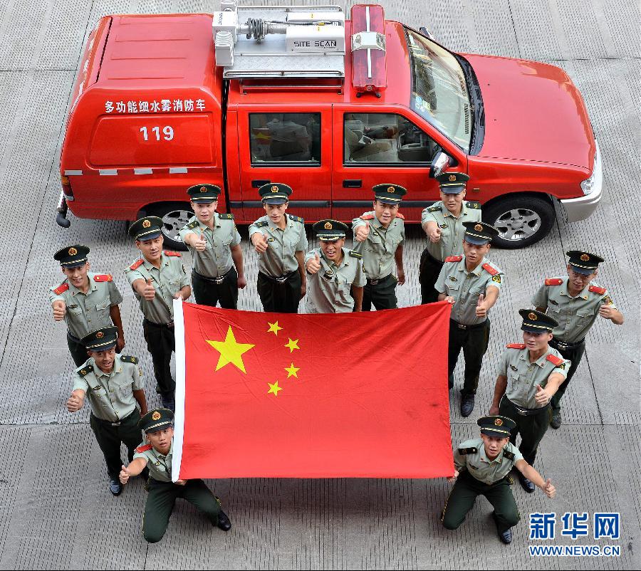  9月25日，武警浙江嘉興消防官兵與國旗合影。