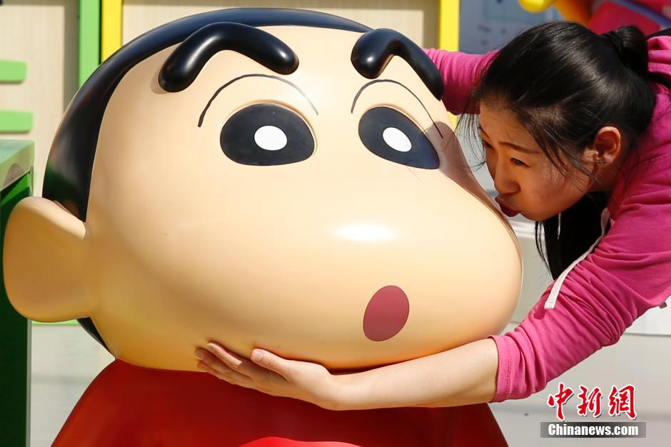 4月22日，游客與蠟筆小新合影?！跋灩P小新25周年紀(jì)念特展”日前在北京開(kāi)展，吸引了不少市民游客。