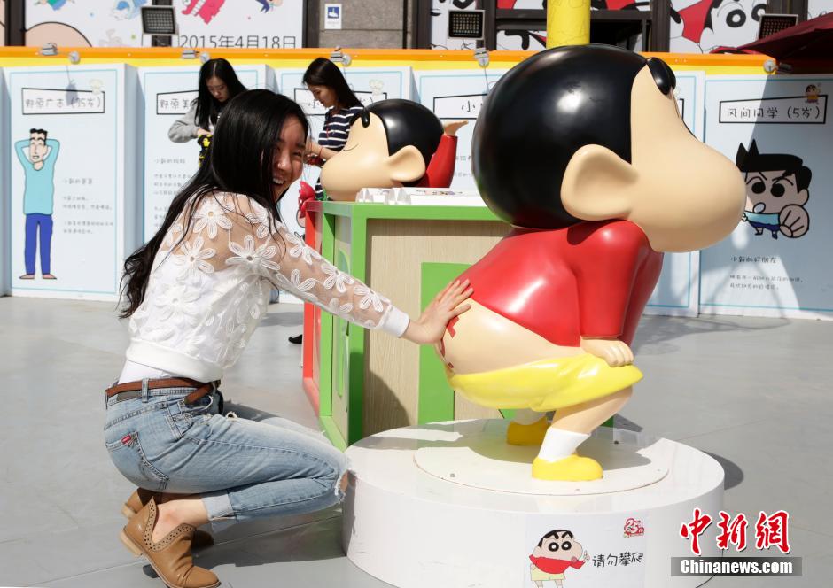 4月22日，游客與蠟筆小新合影?！跋灩P小新25周年紀(jì)念特展”日前在北京開(kāi)展，吸引了不少市民游客。