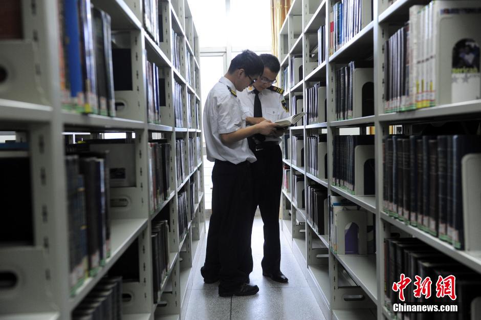 5月8日，武漢輕工大學(xué)保安吳濤與江力在圖書館交流學(xué)習(xí)。中新社發(fā) 張暢 攝