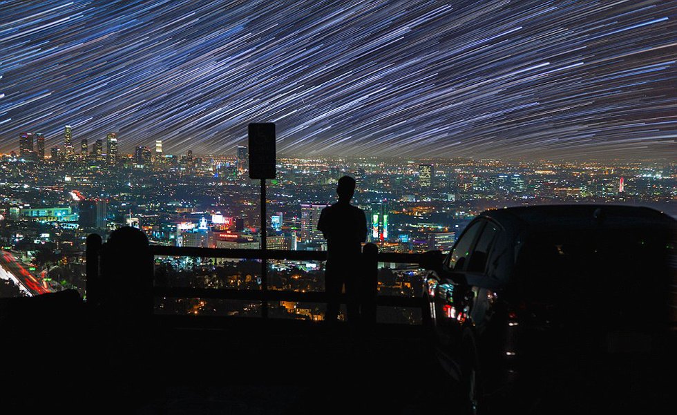 照片中，一名男子看著流星和隕星劃過天空。（網(wǎng)頁截圖）