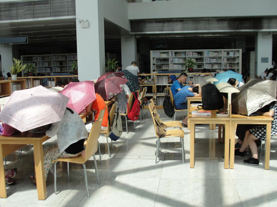 圖書館內(nèi)撐傘讀書的民眾。