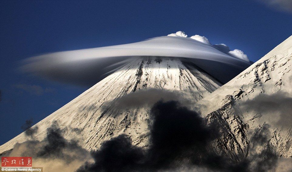 火山上籠罩著類似于外星飛碟形狀的云彩，場景猶如科幻大片。