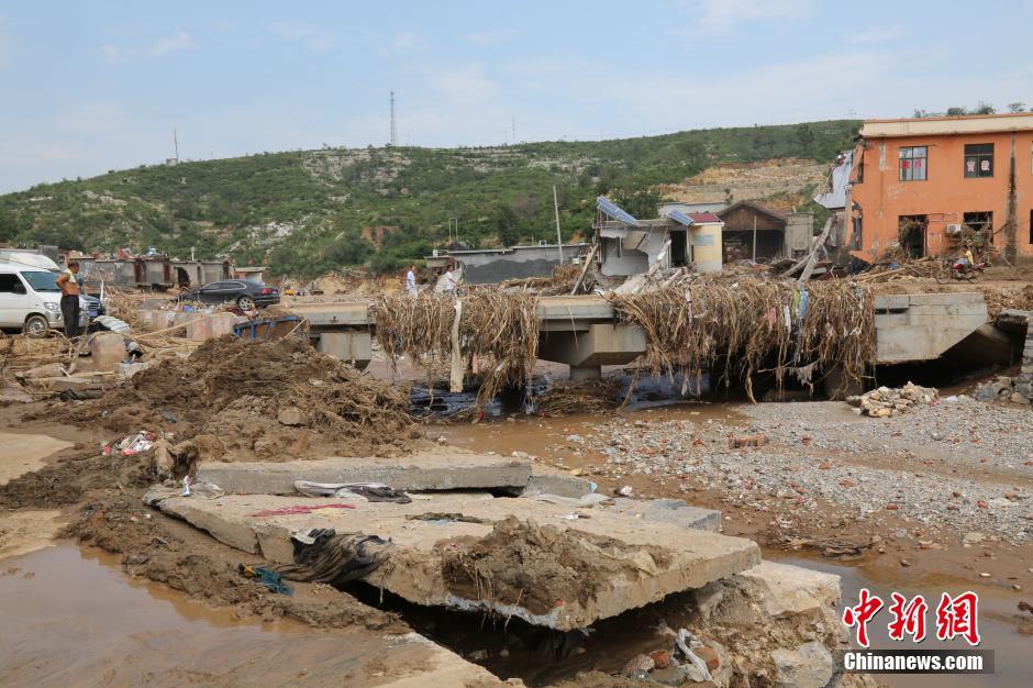 圖為洪水過后，坍塌的橋梁上遺落大量雜草。