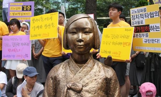 7月2日，在韓國首爾的日本駐韓國大使館前，民眾在慰安婦少女像旁手持標(biāo)語參加抗議活動(dòng)。