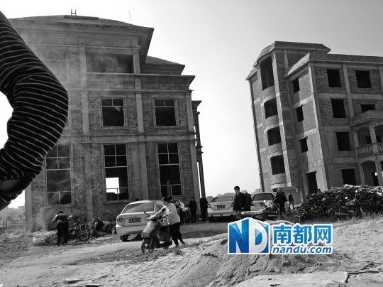 兩棟被舉報的違建樓下昨日一度聚集了超過百人，城管離開后逐漸散去。南都記者張志韜實習生宋超攝