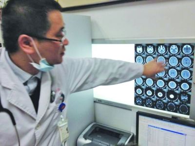 醫(yī)生在查看男孩的腦部CT片。薛馬義 攝