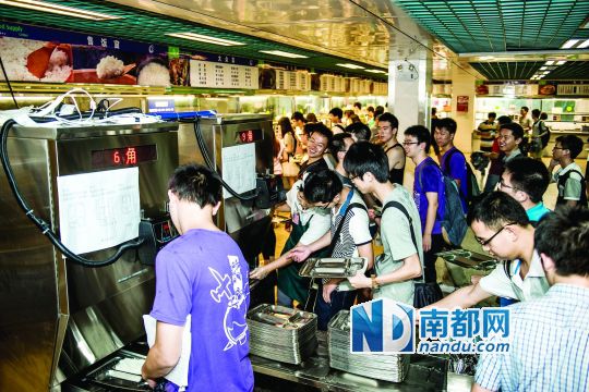 昨日，華南理工大學(xué)一食堂內(nèi)，學(xué)生們正在使用新安裝的自動(dòng)打飯機(jī)打飯。中新社發(fā)