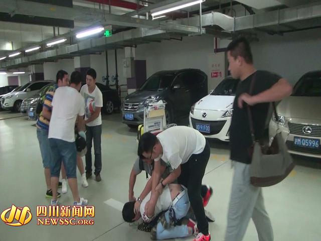辦案人員在機(jī)場(chǎng)停車場(chǎng)抓獲胡某及其女友（警方視頻截圖）。